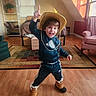 Tatum joined the competition — help win amazing prizes! child, cowboy_hat, costume, smiling, indoors, living_room, wood_floor, rug, armchair, sofa, window, sunlight, plant, bookshelf, sportswear, boots, standing, playful, portrait, happy