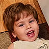 Tatum joined the competition — help win amazing prizes! child, toddler, smiling, laughing, portrait, face, indoors, carpet, wood_floor, clothing, shirt, blond_hair, brown_hair, happy, sitting, lying_down, close_up, home, warm_lighting, photography