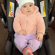 Milla joined the competition — help win amazing prizes! adorable, baby, car_seat, child, clothing, cute, floor, indoor, infant, looking, person, pink_jacket, pom_poms, portrait, purple_pants, seated, sock, warm_clothing, white_hat, young_child