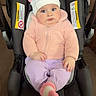 adorable, baby, car_seat, child, clothing, cute, floor, indoor, infant, looking, person, pink_jacket, pom_poms, portrait, purple_pants, seated, sock, warm_clothing, white_hat, young_child