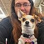 animal, closeup, collar, cute, dog, face, glasses, happy, indoor, long_hair, looking_at_camera, person, pet, pink_sweater, portrait, shopping_cart, small_dog, store, tag, woman