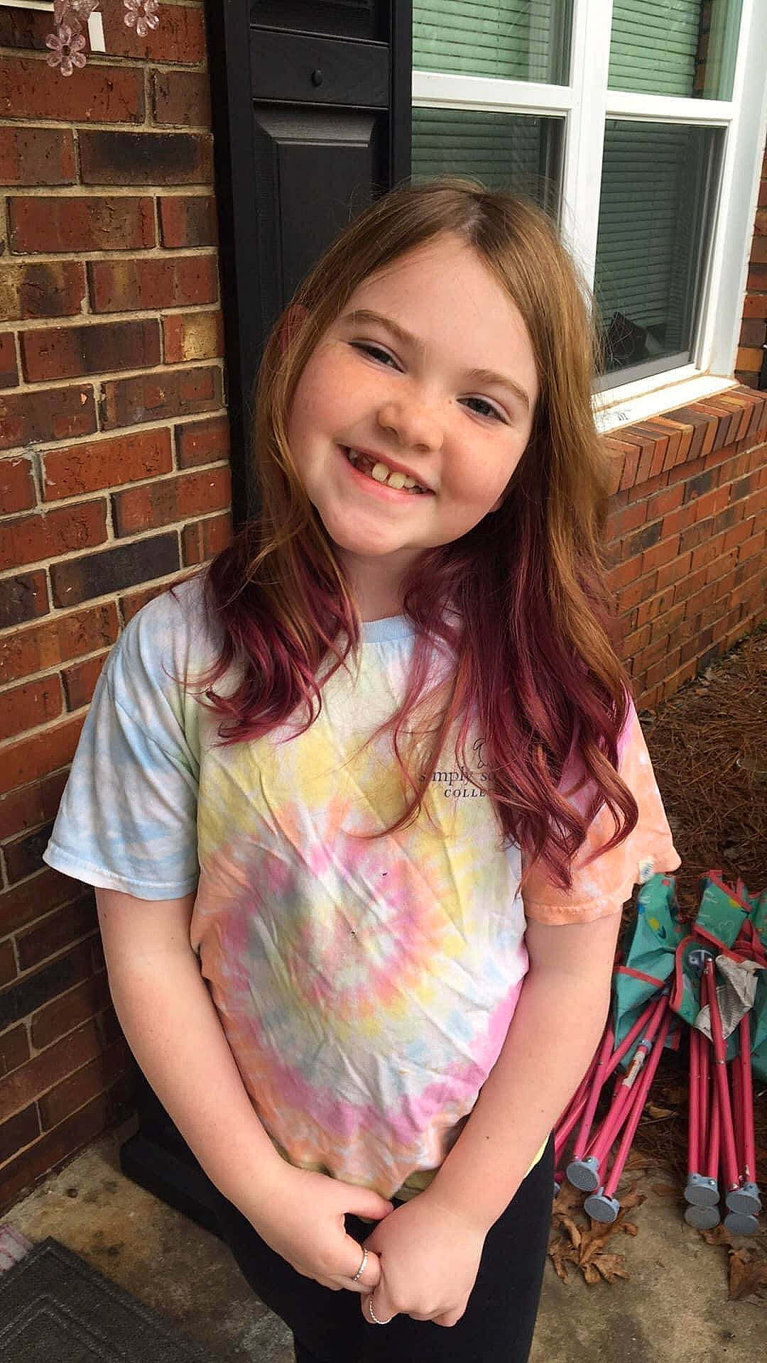 Kyndal joined the competition — help win amazing prizes! blond, brick, brickwork, brown_hair, child, facial_expression, fun, grass, happy, iris, joy, long_hair, magenta, pattern, person, pink, sitting, sleeve, smile, t_shirt