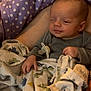 baby, blanket, pacifier, polka_dot, purple, sleeping, infant, clothing, pattern, dinosaur, bed, bedding, hand, face, person, cozy, resting, cute, soft, indoors