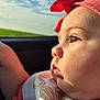 Zulema is registered to the contest to win money with this photo: baby, child, face, profile, headband, pink, bow, car, window, sky, clouds, outdoor, clothing, cute, infant, portrait, gazing, soft_light, expression, young