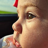 Zulema is registered to the contest to win money with this photo: baby, child, face, profile, close_up, headband, pink, bow, skin, eyelashes, soft_light, outdoor, sky, expression, curious, infant, portrait, cute, young, clothing