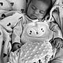 baby, sleeping, blanket, heart_pattern, cozy, soft_texture, cute_outfit, animal_face, infant, peaceful, resting, monochrome, child, hands, clothing, portrait, closeup, warm, comfort, toddler