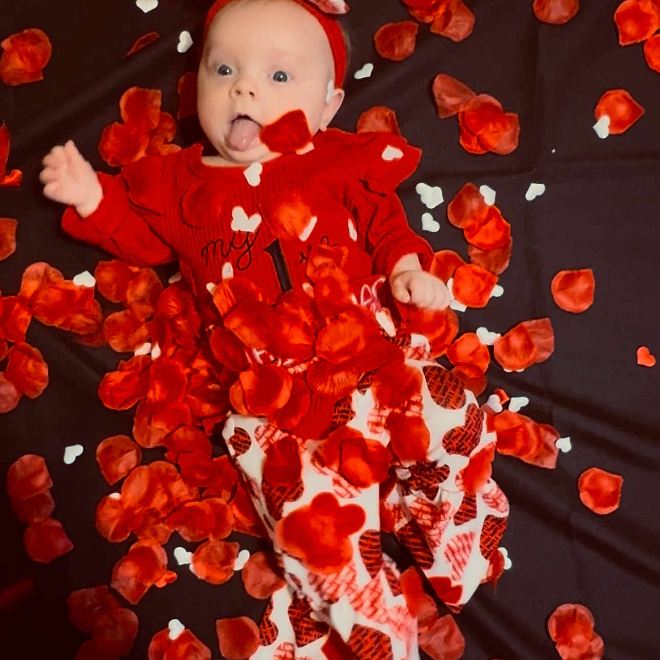 Olivia is registered to the contest to win money with this photo: baby, blanket, bodypart, clothing, dress, face, finger, flower, glove, hand, happy, hat, head, leaf, person, petal, photography, plant, portrait, smile