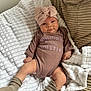 baby, blanket, bow, child, clothing, couch, cozy, cute, face, headwrap, indoors, infant, infant_girl, onesie, person, portrait, relaxing, smile, socks, soft_texture
