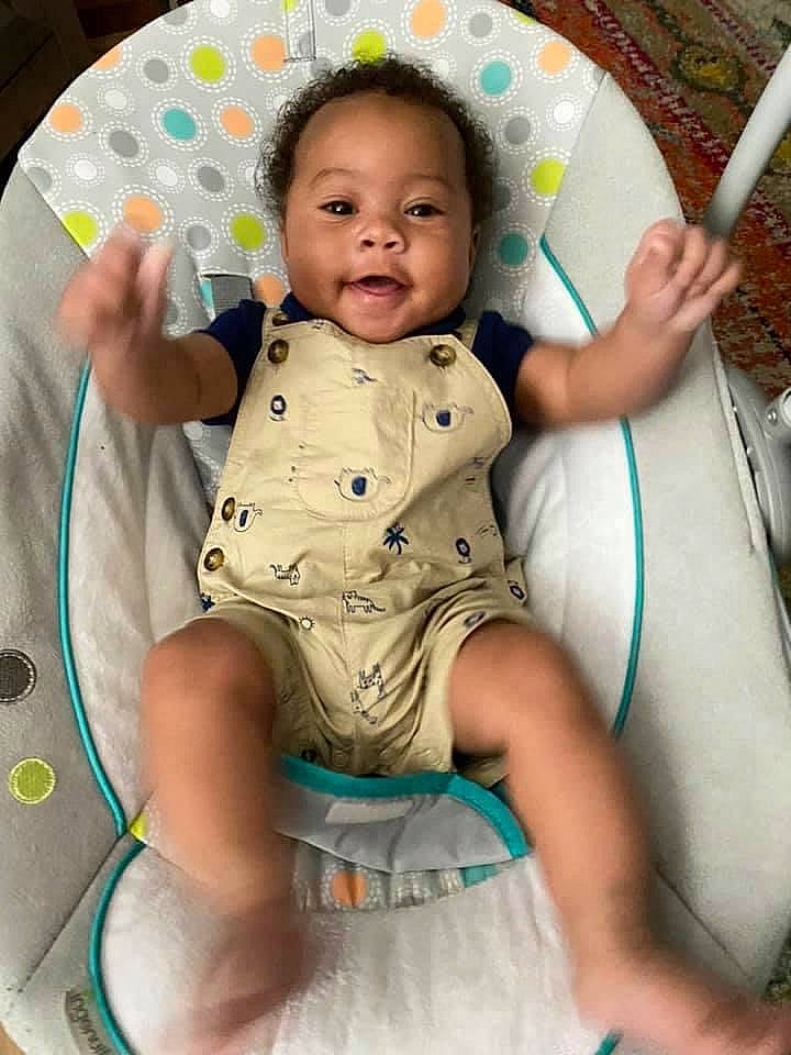 Jamari is registered to the contest to win money with this photo: arm, baby, baby_products, baby_toddler_clothing, chair, cheek, chest, child, comfort, finger, fun, hand, happy, leg, leisure, organ, person, pink, skin, smile