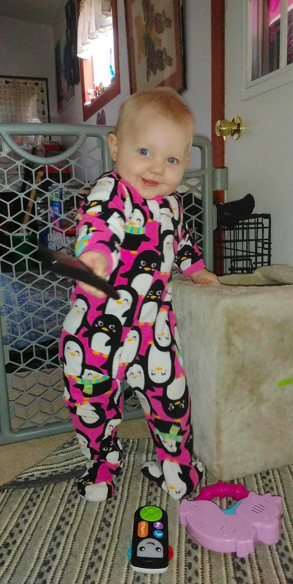 Dawn joined the competition — help win amazing prizes! toddler, child, pajamas, penguin_pattern, remote_control, toy, indoor, carpet, smiling, person, footed_pajamas, home, door, baby, play, furniture, window, curtain, baby_toys, floor