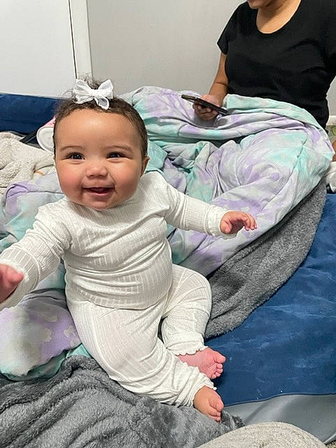 Alanee is registered to the contest to win money with this photo: baby, baby_products, baby_toddler_clothing, cheek, child, comfort, face, flooring, fun, gesture, grass, happy, human, joy, person, play, purple, room, sitting, smile