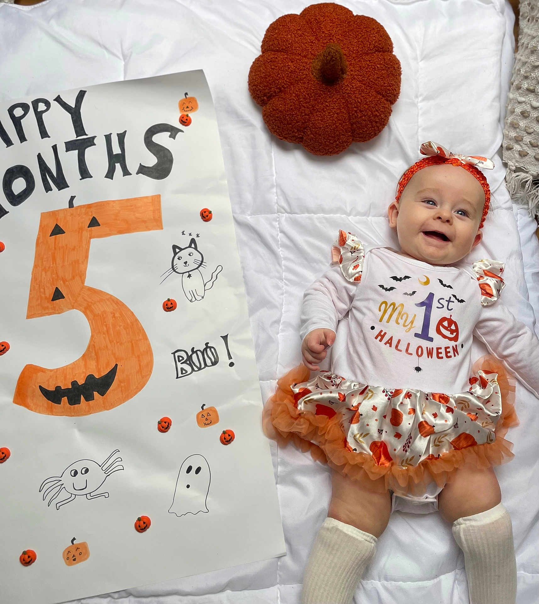 Alayïah participe au concours pour gagner de l'argent avec cette photo : baby, celebration, child, costume, cute, decorations, drawing, face, halloween, headband, infant, lying_down, orange, poster, pumpkin, quilt, skirt, smile, sock, white_background