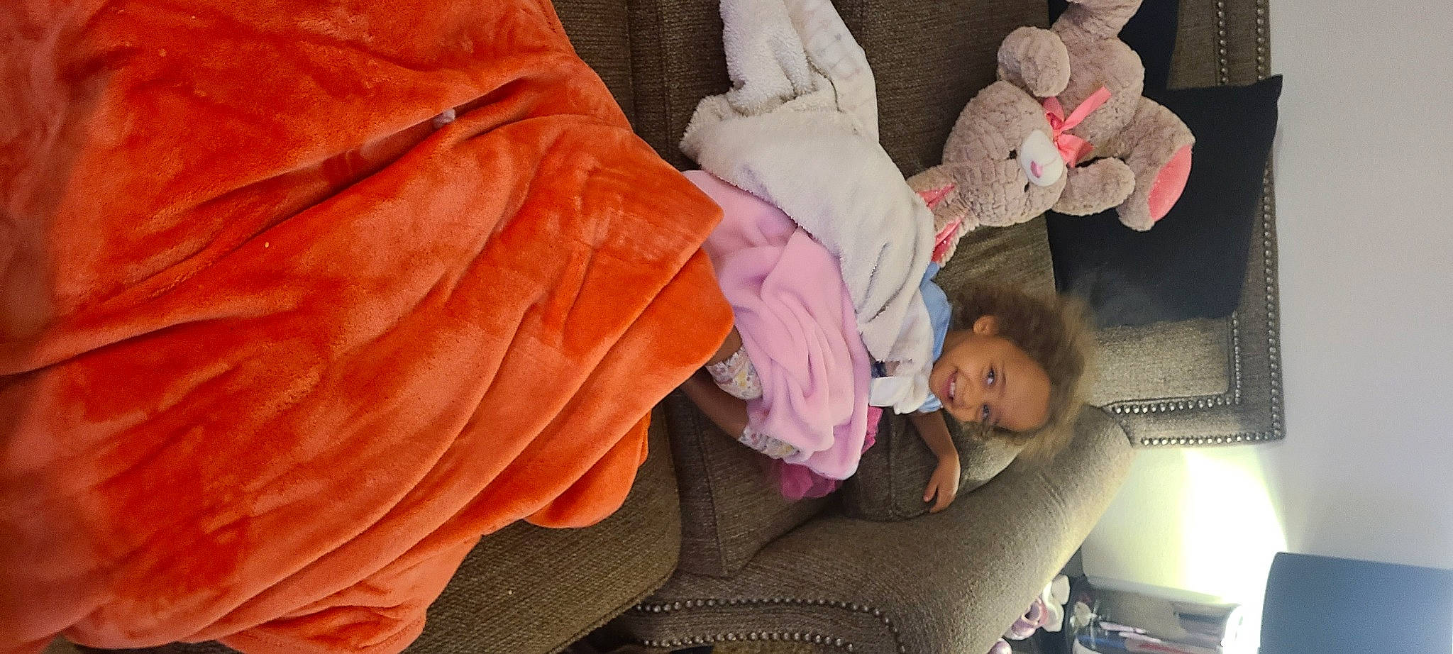 Emmy is registered to the contest to win money with this photo: arm, baby, baby_products, baby_toddler_clothing, child, comfort, finger, hand, head, human_body, joy, leg, linens, outerwear, person, pink, room, shorts, sitting, thumb