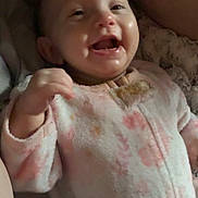 Winter is registered to the contest to win money with this photo: baby, infant, smiling, onesie, bottle, blanket, happy, child, cute, sleepwear, person, indoors, face, mouth_open, hand, soft, pink, cozy, lying_down, young