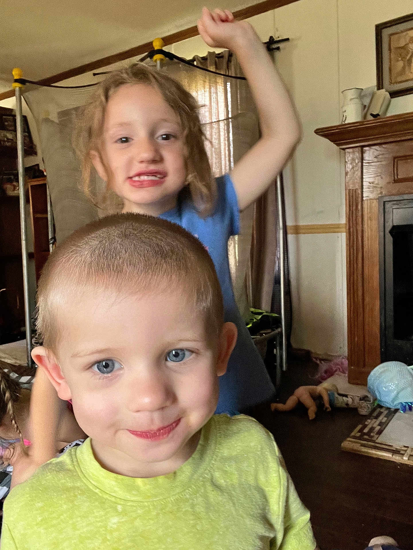 Jace joined the competition — help win amazing prizes! child, boy, girl, indoor, living_room, smile, playful, curly_hair, short_hair, yellow_shirt, blue_shirt, toys, floor, furniture, curtains, fireplace, home, happy, person, casual