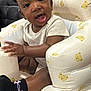 Cali is registered to the contest to win money with this photo: baby, child, infant, cushion, seat, white_clothing, black_socks, pink_bows, bear_pattern, smiling, happy, indoors, cute, young_child, sitting, furniture, person, portrait, playful, comfortable