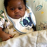 Kyzon is registered to the contest to win money with this photo: baby, infant, child, portrait, face, curly_hair, wide_eyed, sitting, crib, blanket, bib, elephant, animal_print, clothing, nursery, bedding, indoors, cozy, photography, cute