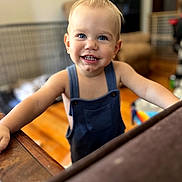 Hayes joined the competition — help win amazing prizes! toddler, child, smiling, portrait, indoors, overalls, denim, blue_eyes, blond_hair, baby, standing, happy, face, arms, home, living_room, furniture, table, natural_light, photography