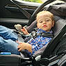 automotive, baby, blond_hair, blue_eyes, buckled, car, car_seat, child, face, indoors, infant, outdoor_view, passenger, plaid_shirt, portrait, safe, seatbelt, sitting, vehicle, window