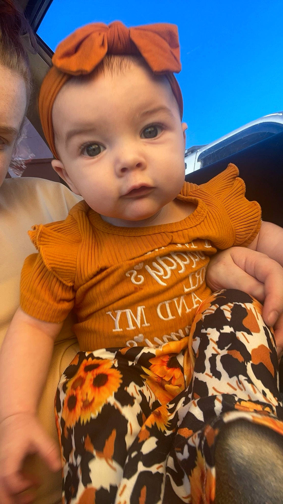 Richelle is registered to the contest to win money with this photo: baby, cheek, child, eye, finger, fun, happy, hat, human, human_body, leisure, nose, orange, organ, pattern, person, sitting, skin, sleeve, t_shirt
