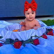 Alaia is registered to the contest to win money with this photo: baby, background, child, curious, cute, flower, flower_arrangement, flower_petals, greenery, headband, infant, nature, outdoor, portrait, red_bow, roses, sitting, skin, tub, white_cloth