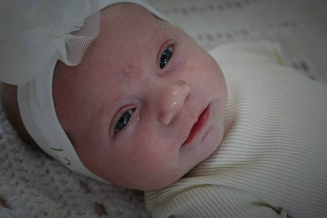 Romy participe au concours pour gagner de l'argent avec cette photo : baby, baby_toddler_clothing, cheek, child, comfort, eye, eyebrow, eyelash, happy, headwear, iris, linens, lip, mouth, no_expression, nose, person, portrait_photography, room, skin