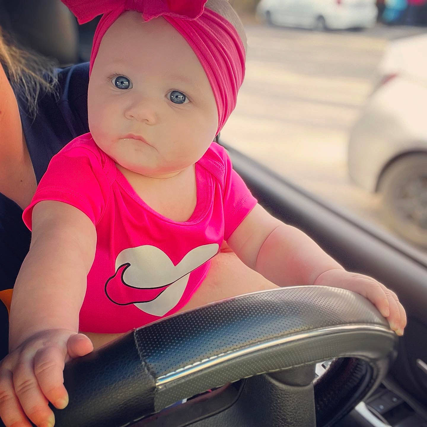 Jaelyn is registered to the contest to win money with this photo: arm, automotive_design, automotive_lighting, baby, baby_toddler_clothing, cap, car, eye, face, facial_expression, finger, hand, happy, head, headwear, light, person, pink, skin, toddler