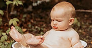 David is registered to the contest to win money with this photo: baby, child, outdoor, basin, feet, nature, greenery, infant, skin, cute, expression, leaves, ground, sitting, barefoot, summer, young, water, playful, portrait