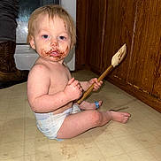 Coulson joined the competition — help win amazing prizes! toddler, child, kitchen, floor, diaper, chocolate, spatula, messy, face_smear, hands, wooden_cabinet, appliance, boots, curious, indoor, light_skin, blue_eyes, short_hair, sitting, floor_tiles