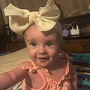 Charlotte joined the competition — help win amazing prizes! baby, bow, headband, child, smile, indoor, quilt, colorful, clothing, sitting, cute, infant, person, happy, portrait, eyes, hand, fabric, room, furniture
