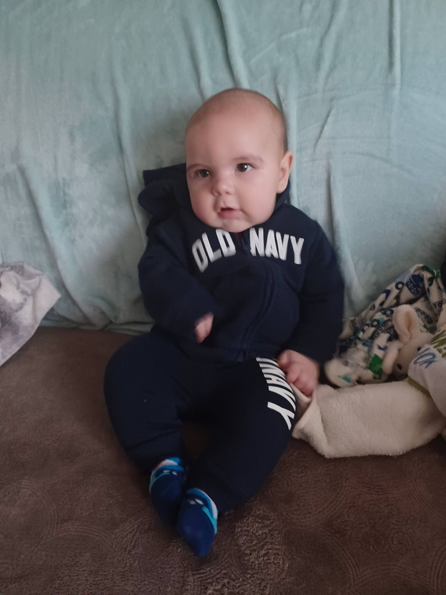 Lucas is registered to the contest to win money with this photo: arm, baby, baby_toddler_clothing, cheek, comfort, cool, couch, elbow, eye, facial_expression, finger, flooring, iris, knee, leg, person, skin, sleeve, sock, t_shirt