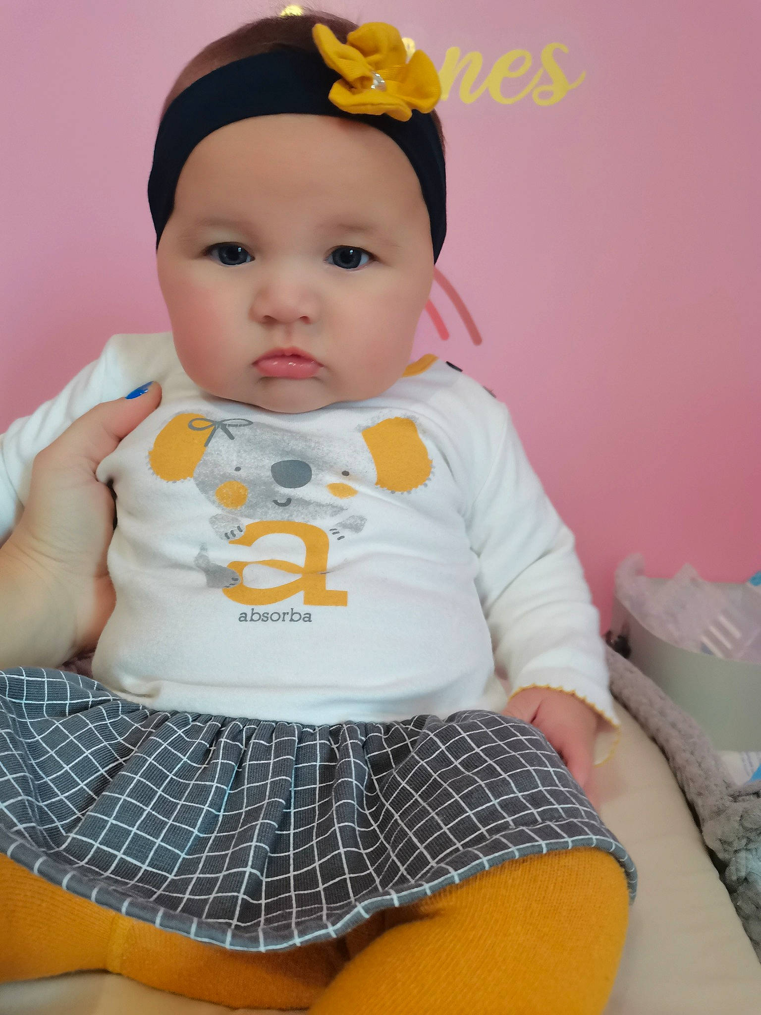 Anaïs participe au concours pour gagner de l'argent avec cette photo : baby, baby_toddler_clothing, cap, cheek, child, clothing, face, facial_expression, head, headwear, knee, neck, pattern, person, pink, skin, sleeve, standing, t_shirt, textile