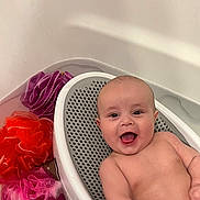 Zavier is registered to the contest to win money with this photo: baby, bathtub, bath_seat, bathroom, child, colorful, foam, happy, infant, loofah, mesh, naked, person, plastic, portrait, pouf, relaxing, sitting, smile, water
