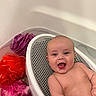 baby, bathtub, bath_seat, bathroom, child, colorful, foam, happy, infant, loofah, mesh, naked, person, plastic, portrait, pouf, relaxing, sitting, smile, water