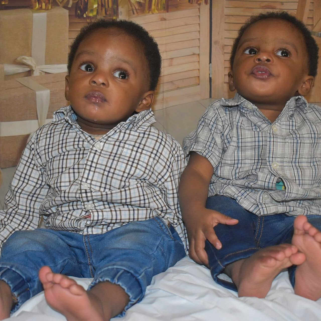 Sokowonchin is registered to the contest to win money with this photo: baby, barefoot, child, curious, cute, family, floor, gift, indoor, infant, jeans, pair, people, plaid_shirt, portrait, present, sitting, toddler, white_sheet, wooden_panel