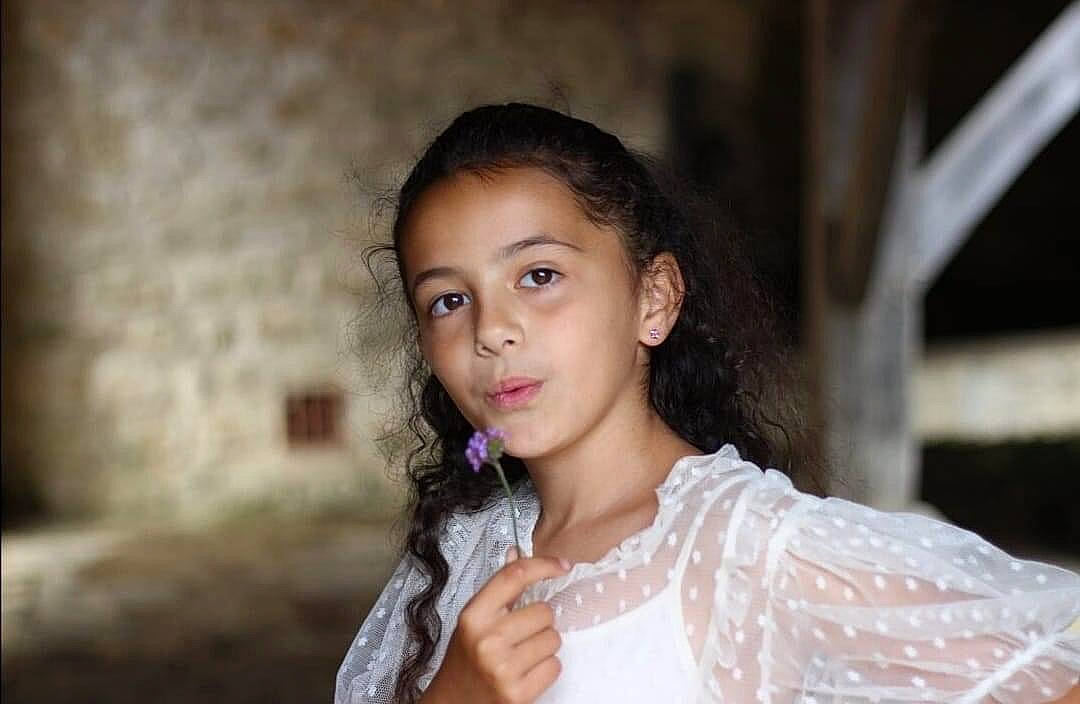 Sofia participe au concours pour gagner de l'argent avec cette photo : black_hair, brown_hair, embellishment, event, eye, eyebrow, eyelash, face, fashion_design, flash_photography, gesture, happy, iris, jewellery, lip, long_hair, neck, person, skin, smile