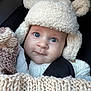 baby, child, hat, knitwear, blanket, face, blue_eyes, cute, warm_clothing, closeup, infant, portrait, cozy, fur_hat, baby_carrier, soft_texture, winter_wear, person, headgear, adorable