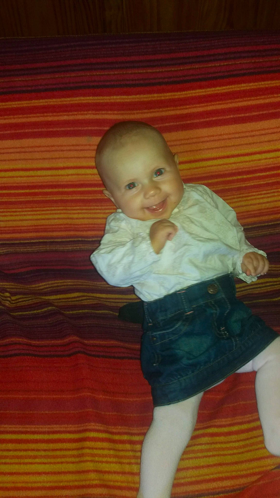 Thalia a rejoint le concours — aidez-le/la à gagner de superbes lots ! baby, baby_toddler_clothing, cheek, child, comfort, flooring, hardwood, human_body, human_leg, joy, knee, pattern, person, sitting, sleeve, smile, sock, t_shirt, thumb, toddler