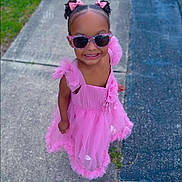 Viviana is registered to the contest to win money with this photo: child, girl, pink_dress, sunglasses, hair_bows, sidewalk, grass, asphalt, smile, happy, fashion, outdoor, cute, portrait, person, summer, playful, toddler, dress, accessories