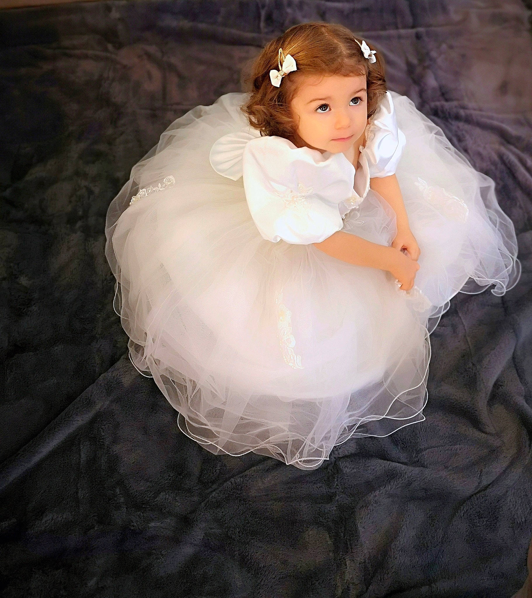 Ilana participe au concours pour gagner de l'argent avec cette photo : baby_toddler_clothing, bridal_accessory, bridal_clothing, bridal_party_dress, day_dress, dress, embellishment, eye, eyelash, face, fashion_design, flash_photography, formal_wear, gown, hair, head, headpiece, human_body, person, toy