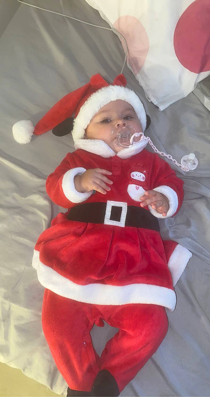 Lya participe au concours pour gagner de l'argent avec cette photo : baby, baby_toddler_clothing, carmine, child, christmas, christmas_decoration, christmas_eve, cosplay, costume, costume_hat, event, fictional_character, fun, fur, headwear, holiday, lap, person, red, santa_claus