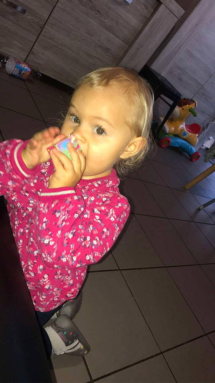 Lya a rejoint le concours — aidez-le/la à gagner de superbes lots ! baby, baby_products, baby_toddler_clothing, cheek, child, drinking, drinkware, flooring, fun, happy, iris, lip, mouth, nose, person, pink, play, room, sitting, skin