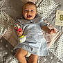 Albane a rejoint le concours — aidez-le/la à gagner de superbes lots ! baby, blanket, child, cute, diaper, happy, indoors, infant, lying_down, milestone_card, person, playful, portrait, quilt, rattle, smiling, soft_lighting, star_pattern, striped_dress, toy