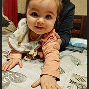 Luna participe au concours pour gagner de l'argent avec cette photo : child, baby, toddler, smiling, face, hands, bib, pacifier, pigtails, hair_ties, adult, caregiver, indoor, table, tablecloth, bedspread, close_up, portrait, happy, furniture
