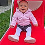 baby, child, pink_hoodie, white_tights, shoes, red_lounge_chair, outdoor, grass, smiling, happy, sitting, person, face, footwear, garden, casual_clothing, cute, infant, playful, daylight