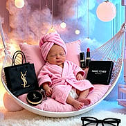 Ivy-Mai is registered to the contest to win money with this photo: baby, pink_robe, towel_turban, hanging_chair, luxury_makeup, lipstick, compact, shopping_bag, glasses, soft_lighting, cushion, carpet, indoor, portrait, relaxing, cosmetics, sleeping, cozy, decor, child