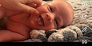 Bentley joined the competition — help win amazing prizes! baby, blanket, cheek, cozy, cute, expression, face, fingers, hand, indoor, infant, knitted_blanket, lying_down, newborn, person, playful, skin, smile, tongue, warm_lighting