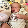 Emberley Hughes is registered to the contest to win money with this photo: newborn, baby, infant, sleeping, face, portrait, indoors, bed, blanket, pajamas, clothing, hand, adult, cozy, home, bedding, floral, textile, relaxed, photography