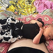 Emberley Hughes joined the competition — help win amazing prizes! baby, infant, sleeping, bed, blanket, cow_print, pink, donut_pattern, bedding, cozy, portrait, indoor, lying_down, resting, peaceful, clothing, black_shirt, human, face, nap