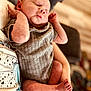 Huntleigh joined the competition — help win amazing prizes! baby, newborn, infant, sleeping, person, arms, clothing, gray_onesie, skin, hand, foot, nail, peaceful, cute, portrait, indoor, holding, closeup, human, resting